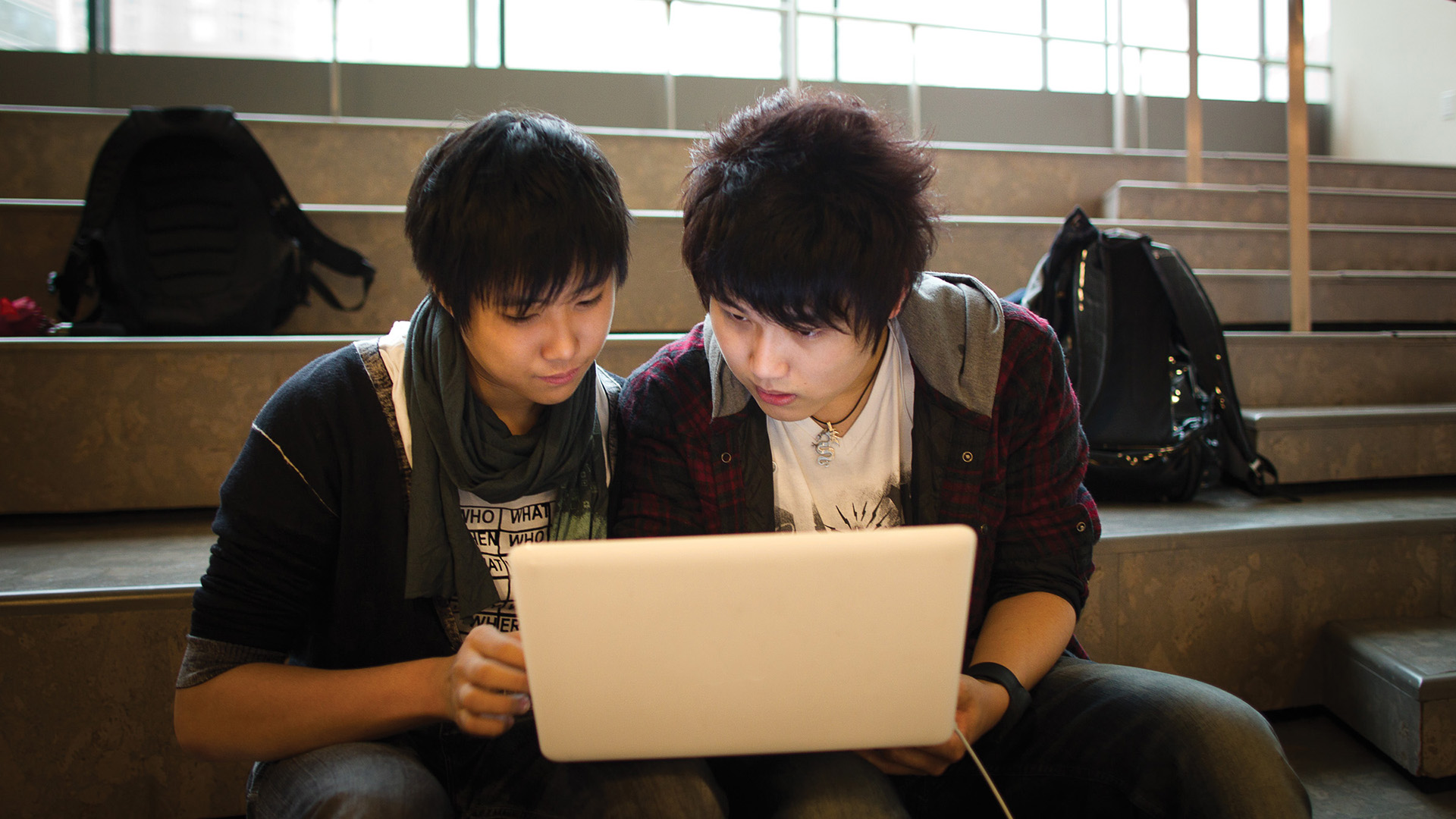 two students looking at a laptop